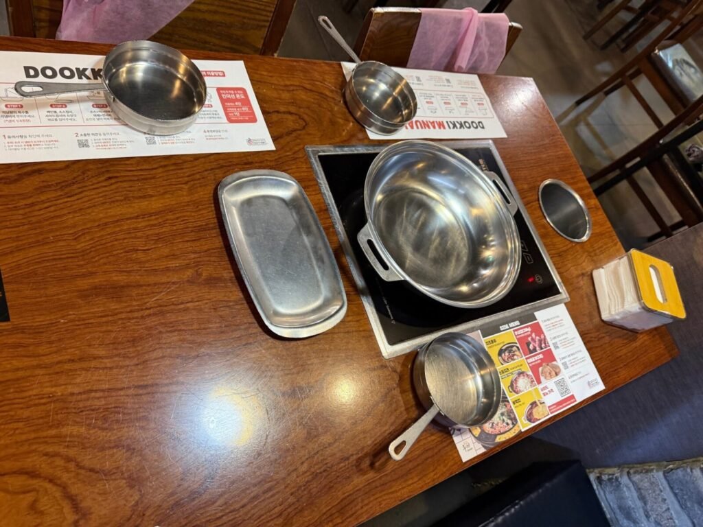 Dookki table setup with built-in induction cooktop and stainless steel pots, Mokdong branch